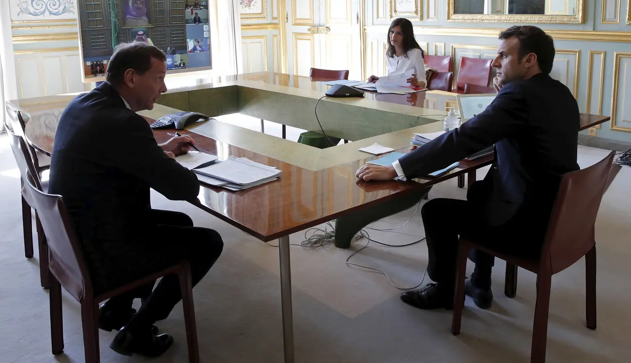 Presiden Prancis Emmanuel Macron (kanan) saat mengikuti KTT Luar Biasa G20 secara virtual dari Istana Elysee di Paris, Prancis, Kamis (26/3/2020). Para pemimpin dunia mengkoordinasikan respons global terhadap pandemi virus corona COVID-19. (Benoit Tessier/Pool via AP)