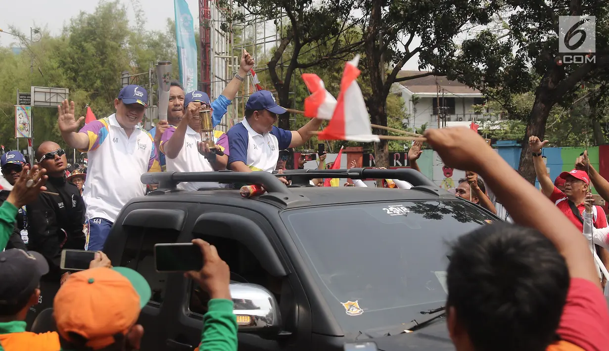 Pembawa api obor Asian Games 2018 melintas di kawasan Slipi, Jakarta, Kamis (16/08). Obor Asian Games 2018 tiba di wilayah Jakarta Barat  dan nantinya akan di teruskan berkeliling Jakarta Utara.(Liputan6.com/  Herman Zakharia)