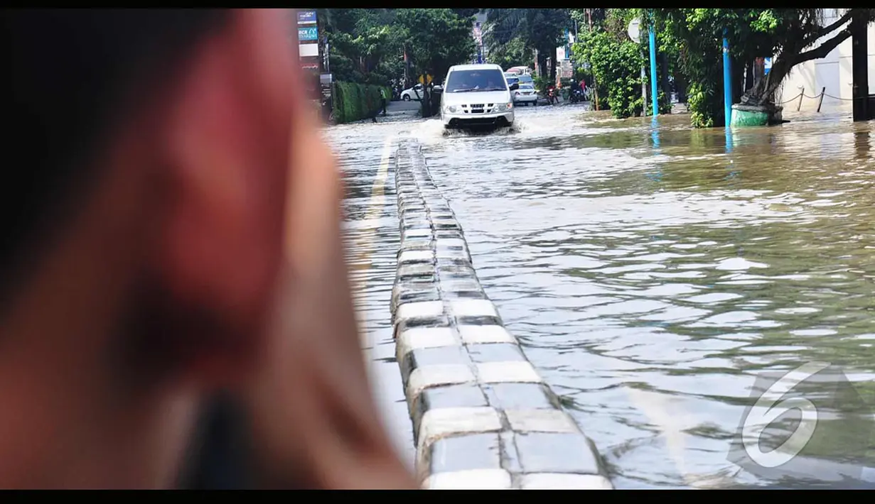 Genangan air banjir yang terjadi di Jalan Kemang Raya mengakibatkan arus lalu lintas menjadi terganggu sejak semalam. , Jakarta, Minggu (27/7/2014) (Liputan6.com/Faizal Fanani)
