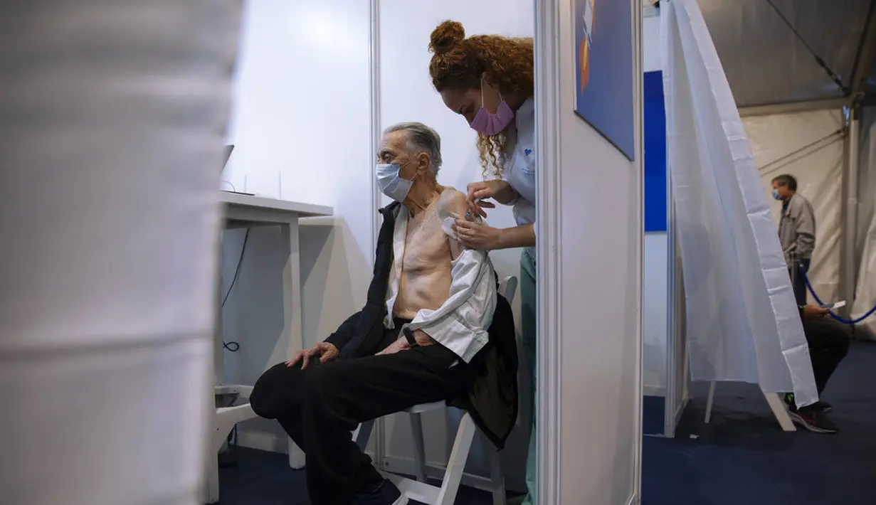 Benno Abramovich (98) menerima vaksin virus corona COVID-19 dari staf medis di Pusat Vaksinasi COVID-19, Tel Aviv, Israel, Minggu (3/1/2021). Israel memiliki tingkat 11,55 dosis vaksinasi per 100 orang. (AP Photo/Oded Balilty)