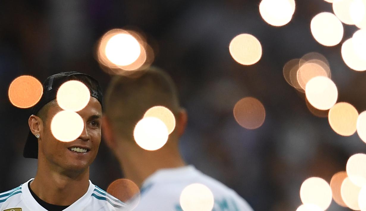 Bintang Real Madrid, Cristiano Ronaldo (kiri) saat merayakan keberhasilan timnya meraih trofi Piala Super Spanyol 2017 di Santiago Bernabeu stadium, Madrid, (16/8/2017). Real menang agregat 5-1. (AFP/Gabriel Bouys)