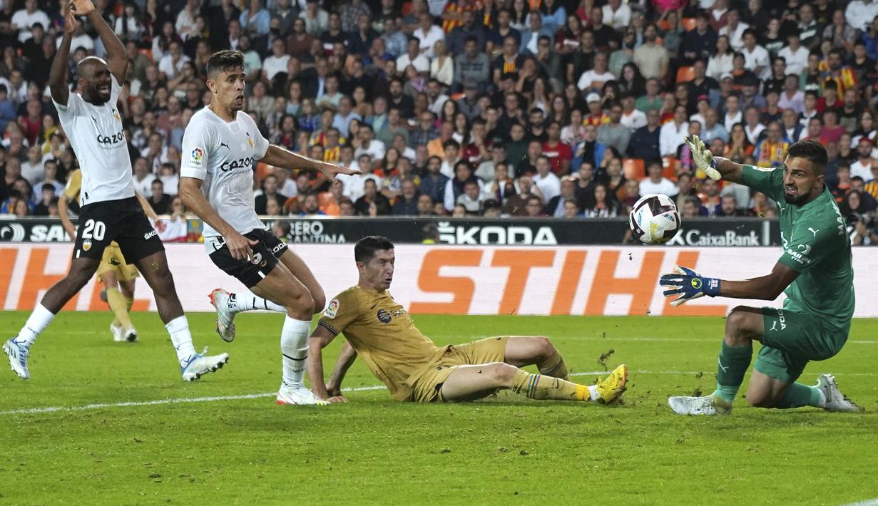 Penyerang Barcelona Robert Lewandowski mencetak gol pembuka ke gawang Valencia pada perpanjangan waktu saat jornada ke-12 La Liga 2022/23 di Mestalla, Minggu (30/10/2022) dini hari WIB. Menghadapi tuan rumah Valencia, Barcelona berhasil menang dengan skor tipis 1-0. (AP Photo/Alberto Saiz)