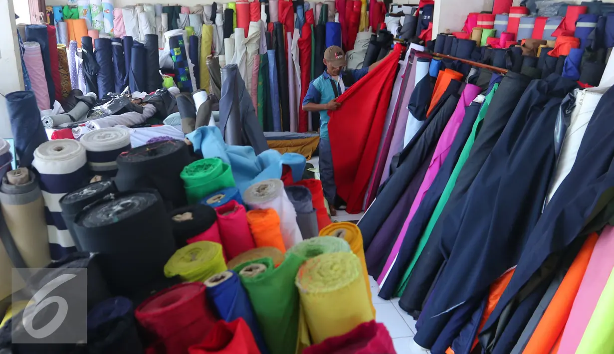 Pekerja merapikan gulungan kain di Pasar Cipadu, Tangerang, Selasa (30/8).Dirjen Industri Kimia, Tekstil, dan Aneka (IKTA) Kemenperin optimistis kinerja industri tekstil dan produk tekstil nasional akan gemilang. (Liputan6.com/Angga Yuniar)