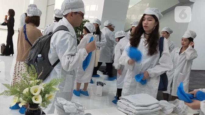 Persiapan memasuki pabrik Oppo di Dongguan, Guangdong, Tiongkok. Pengunjung mengenakan pakaian khusus, topi, dan penutup sepatu. Liputan6.com/Ramdania El Hida