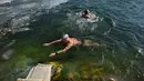 Dua perenang es berenang di danau yang membeku pada hari musim dingin di Beijing (6/1/2021). Berenang di musim dingin adalah kegiatan olahraga yang jarang dijumpai kecuali di beberapa negara dengan musim dingin yang cukup panjang. (AFP/Wang Zhao)