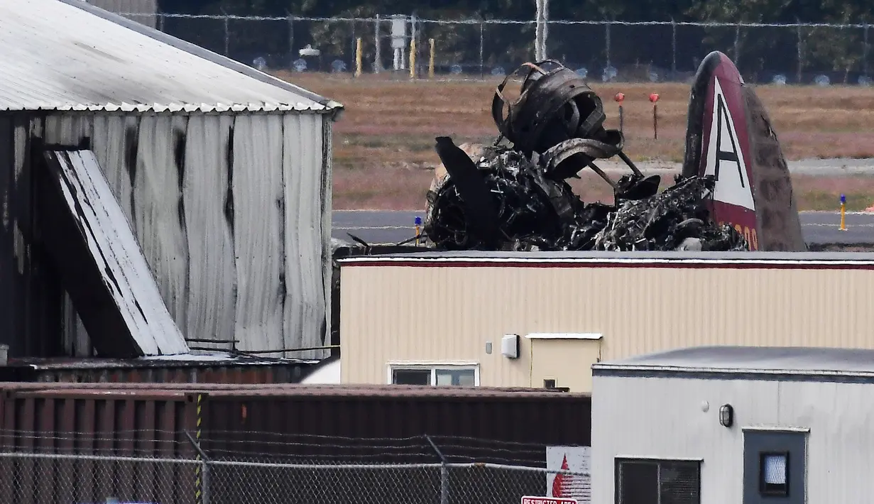 Bangkai pesawat pengebom era Perang Dunia II milik Amerika Serikat setelah jatuh di Bandara Internasional Bradley, Connecticut, Rabu (2/10/2019). Saat insiden terjadi, pesawat tersebut sedang membawa sepuluh penumpang dan tiga kru. (AP Photo/Jessica Hill)