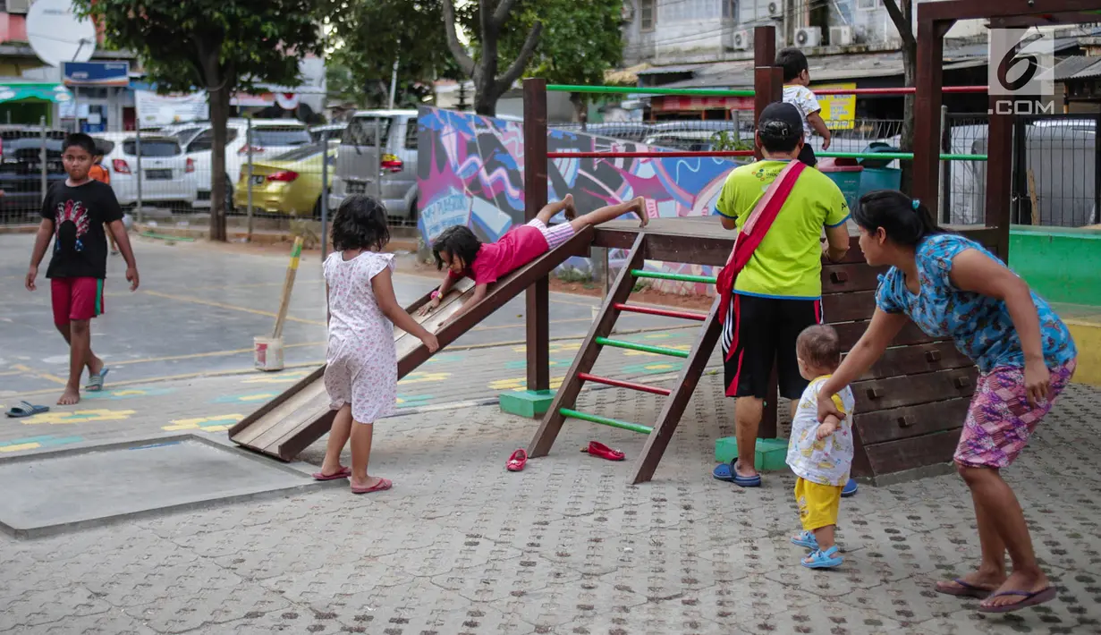 Anak-anak bermain perosotan di Ruang Publik Terbuka Ramah Anak (RPTRA) Rusun Petamburan, Jakarta, Selasa (9/10). Pemprov DKI Jakarta memangkas anggaran pembangunan RPTRA. (Liputan6.com/Faizal Fanani)