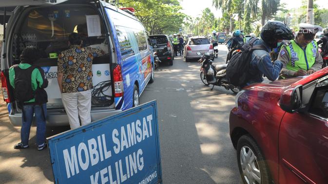 Petugas memeriksa pajak STNK saat melakukan razia gabungan di kawasan Naggewer, Bogor, Selasa (18/9). Razia yang melibatkan unsur POLRI, POM, Dishub dan Dispenda ini menyasar pemilik kendaraan yang belum membayar pajak kendaraan. (Merdeka.com/Arie Basuki)