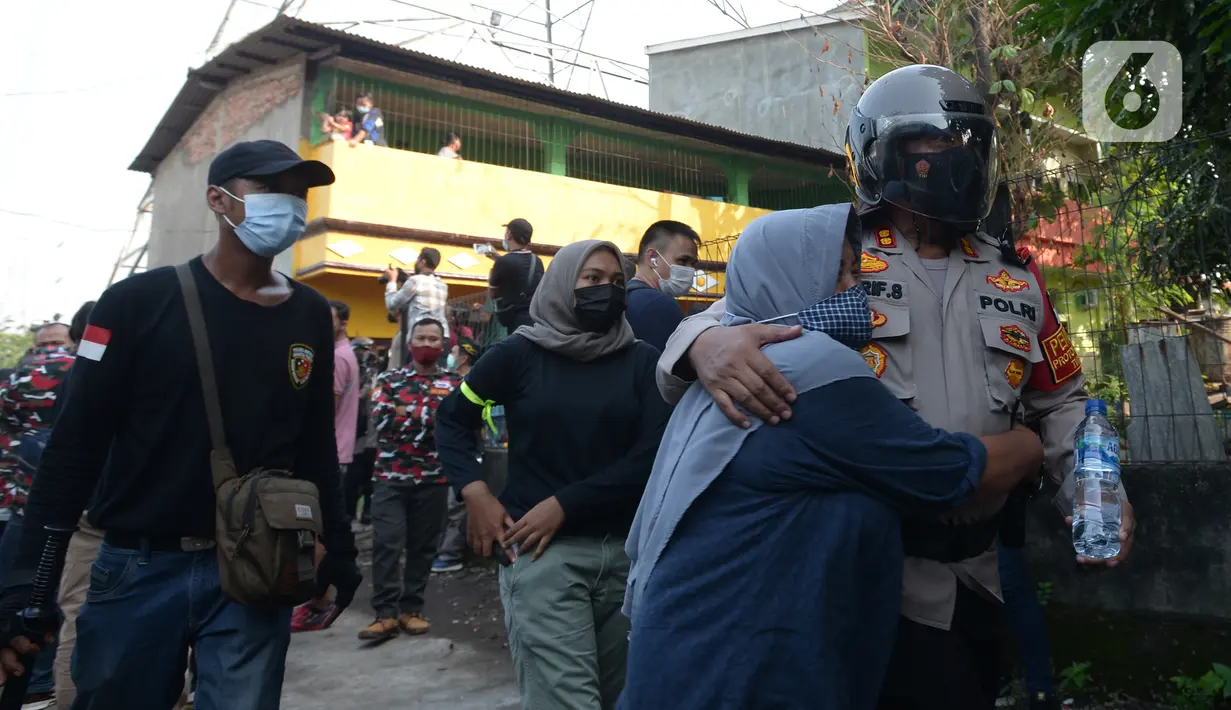 Polisi menenangkan seorang warga saat petugas gabungan melakukan eksekusi lahan rumah warga Kelurahan Pulogebang RT 20 RW 06 (dahulu RT 08/RW 06) di Jakarta, Selasa (8/6/2021). Eksekusi lahan tersebut berakhir ricuh. (merdeka.com/Imam Buhori)