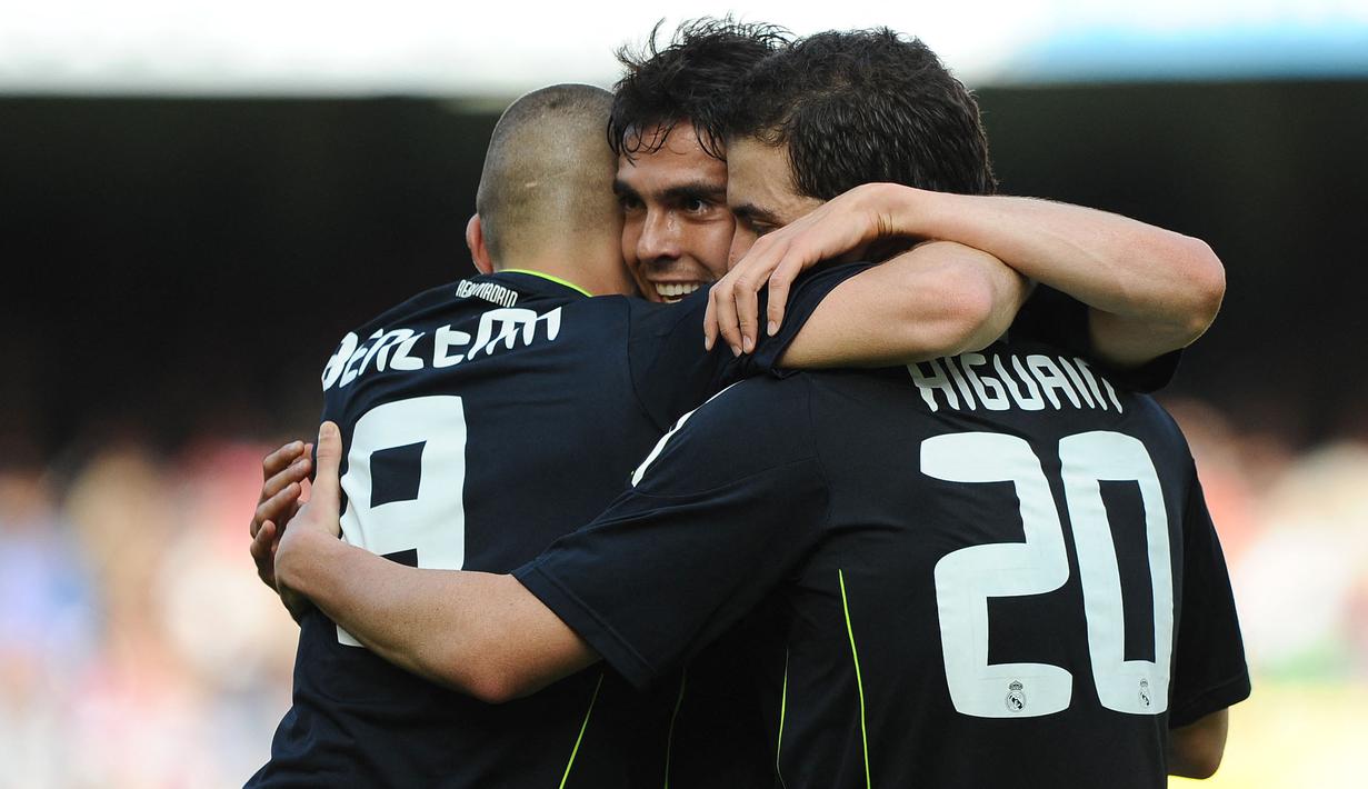 Pemain Real Madrid, Karim Benzema (kiri) dan Gonzalo Higuain (kanan) memeluk rekannya, Ricardo Kaka setelah mencetak gol ke gawang Valencia pada laga lanjutan Liga Spanyol 2010/2011 di Stadion Mestalla, Valencia, 23 April 2011. (AFP/Jose Jordan)
