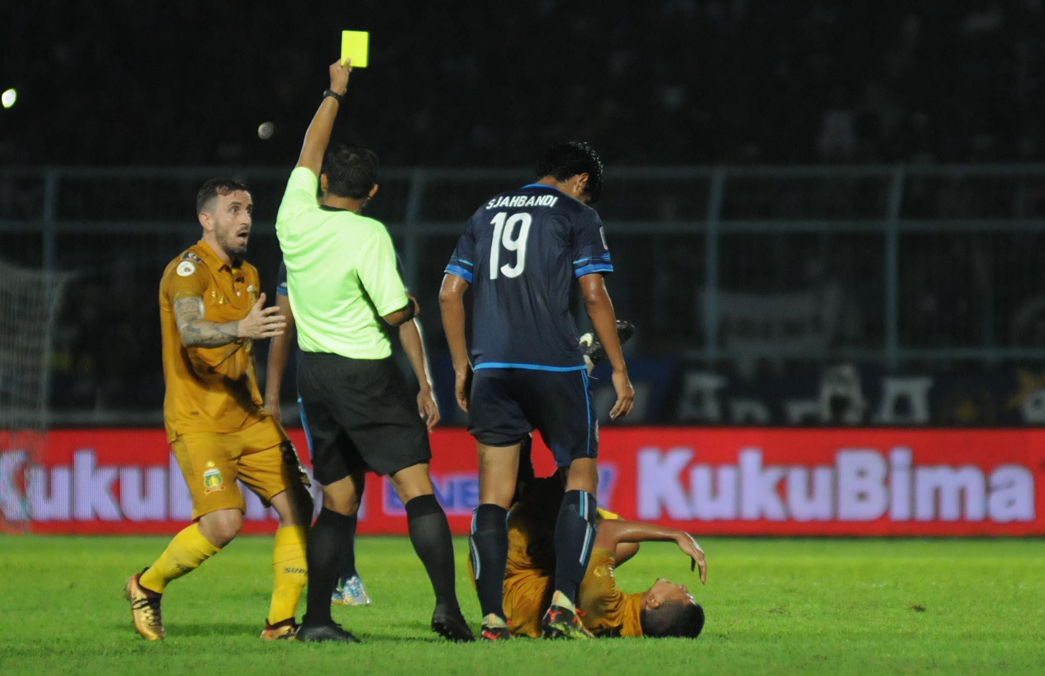 Gelandang Arema FC, Hanif Sjahbandi, melakukan tekel horor ke pemain Bhayangkara FC, T.M Ichsan, dalam pertandingan terakhir Grup E Piala Presiden 2018 di Stadion Kanjuruhan, Malang, Senin (30/1/2018). (Bola.com/Iwan Setiawan)