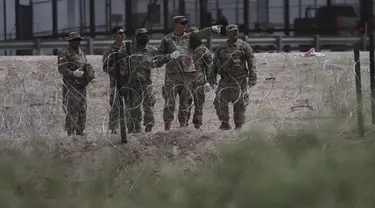 Anggota Garda Nasional Texas memasang penghalang kawat berduri di perbatasan antara El Paso, Texas dan Ciudad Juárez, seperti yang terlihat dari Ciudad Juárez, Meksiko, Rabu (3/5/2023). (AP Photo/Christian Chavez)