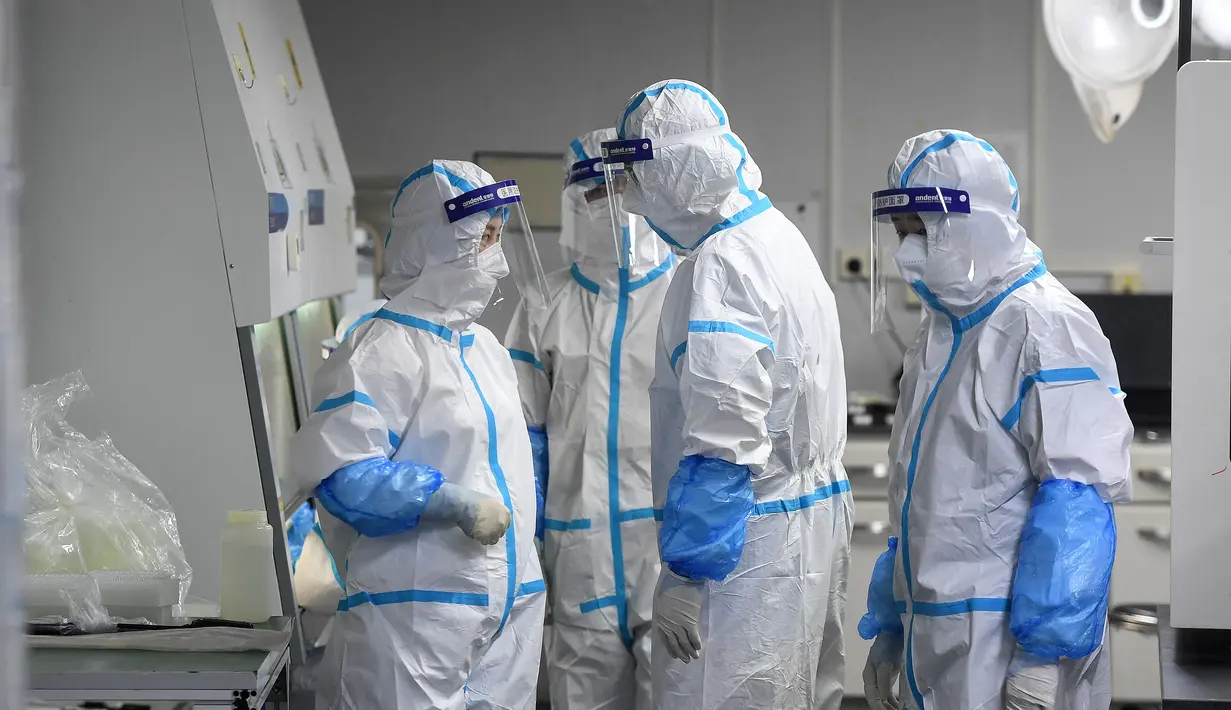 Teknisi laboratorium yang mengenakan alat pelindung diri (APD) mengerjakan sampel yang akan diuji untuk virus corona Covid-19 di laboratorium Fire Eye, fasilitas pengujian Covid-19, di Wuhan di provinsi Hubei tengah China (5/8/2021). (AFP/STR)