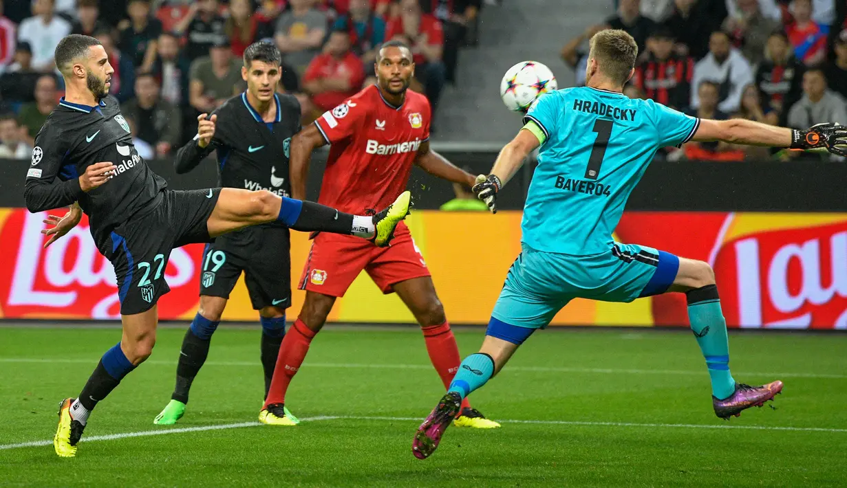 Kiper Bayer Leverkusen Lukas Hradecky berebut bola dengan  bek Atletico Madrid Mario Hermoso dalam matchday kedua Grup B Liga Champions di BayArena, Rabu (14/9/2022) dini hari WIB. Bertandang ke markas Bayer Leverkusen, Atletico Madrid tumbang dengan skor 0-2. (Photo by Sascha Schuermann / AFP)