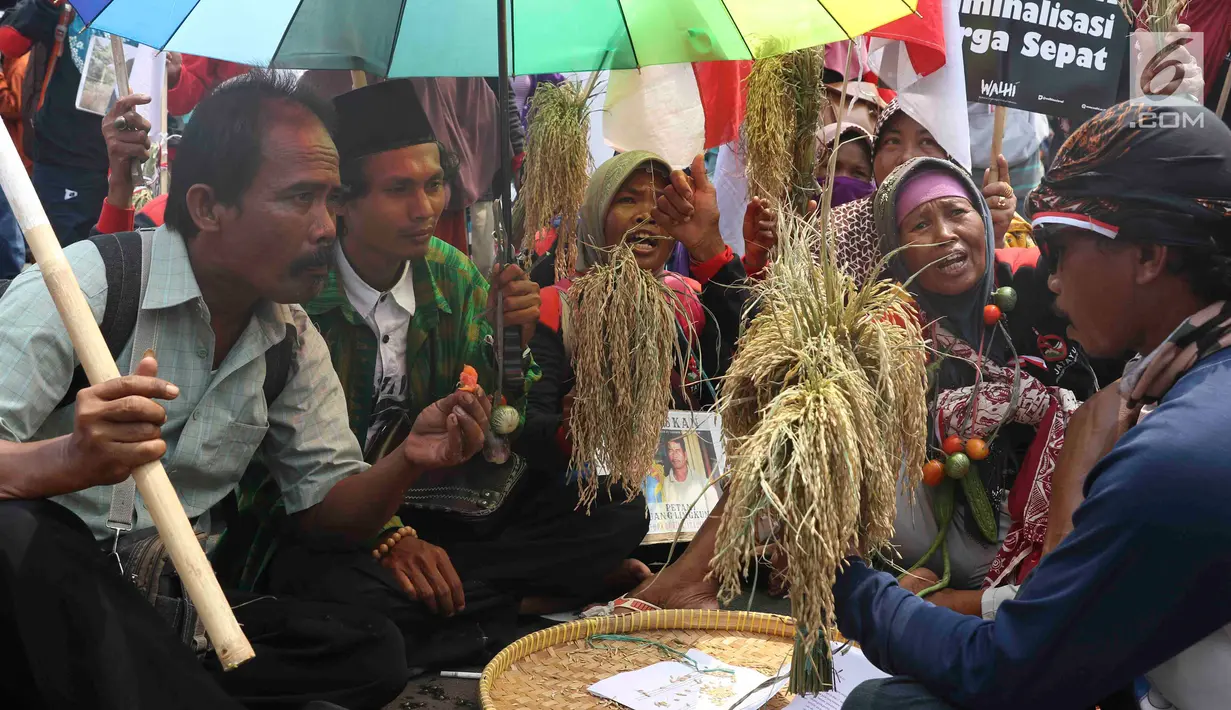Petani dari Jakarta, Jawa Barat, dan Jawa Tengah bersama WALHI membawa Bendera Merah Putih saat unjuk rasa menolak kriminalisasi aktivis lingkungan hidup di depan Istana Negara, Jakarta, Kamis (11/12). (Liputan6.com/Immanuel Antonius)