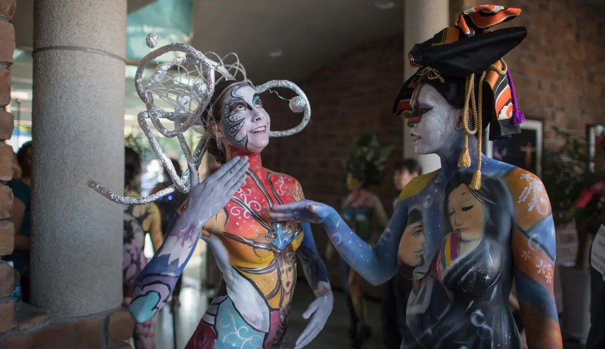 Model bersiap memamerkan lukisan di tubuh mereka selama Daegu International Bodypainting Festival 2017 di Daegu, Korea Selatan, (26/8). Para seniman membutuhkan waktu sedikitnya enam jam untuk menyelesaikan body painting di tubuh model. (Ed JONES / AFP)