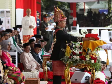 Presiden Joko Widodo (tengah) menyerahkan duplikat bendera pusaka kepada Paskibraka Tarrisa Maharani Dewi saat Upacara Peringatan Detik-detik Proklamasi Kemerdekaan ke-73 di Istana Merdeka, Jakarta, Jumat (17/8). (Liputan6.com/HO/Bian)