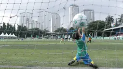 Seorang anak berusaha menangkap bola saat mengikuti MILO Football Clinic Day di Lapangan Simprug, Jakarta, Sabtu (16/12/2017). Sebanyak 500 anak mendapatkan pelatihan dasar teknik sepak bola dari pelatih berpengalaman. (Bola.com/M Iqbal Ichsan)