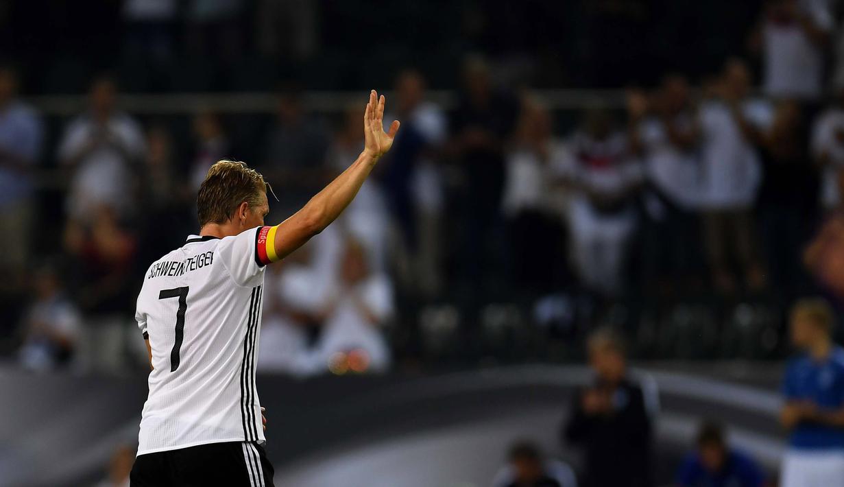 Bastian Schweinsteiger memberikan salam perpisahan usai mengantar Jerman menang melawan Finlandia  2-0 di Monchengladbach, Jerman (1/9/2016) dini hari WIB. (AFP/Patrik Stollarz)