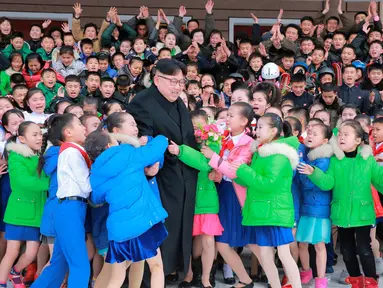 Sejumlah anak memeluk Pemimpin Korea Utara, Kim Jong-un saat berkunjung ke Samjiyon (28/11). Puluhan anak sekolah histeris kegirangan saat bertemu dengan pemimpin negara mereka. (REUTERS/KCNA)