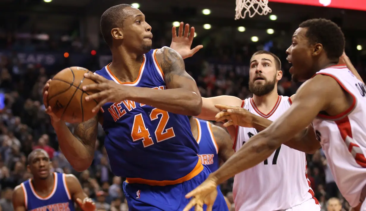 Pebasket New York Knicks Lance Thomas (42) mencoba melepaskan tembakan saat dibayangi para pebasket Toronto Raptors di Air Canada Centre, Toronto, Canada, Rabu(11/11/2015) WIB. Knicks menang Raptors 111-109. (Reuters/Tom Szczerbowski-USA TODAY Sports)