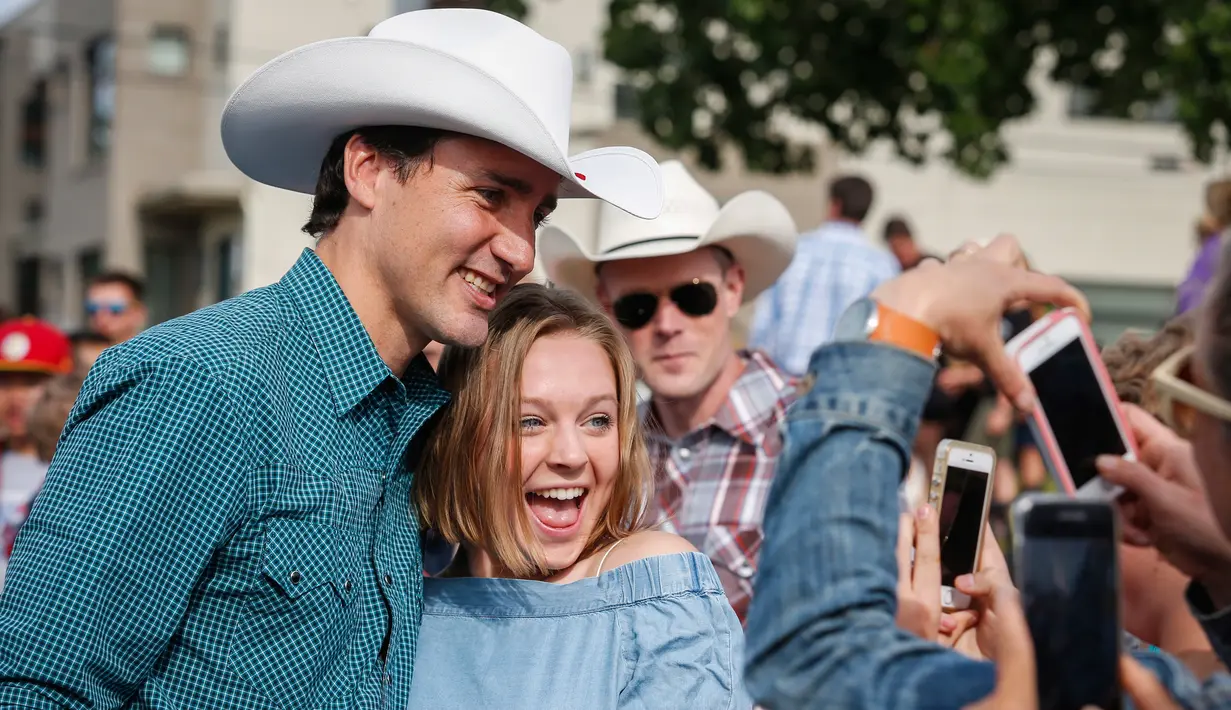 Perdana Menteri Kanada Justin Trudeau berfoto bersama dengan penggemarnya saat acara Calgary Stampede di Calgary, Alberta, Kanada (15/7). (Jeff McIntosh / The Canadian Press via AP)
