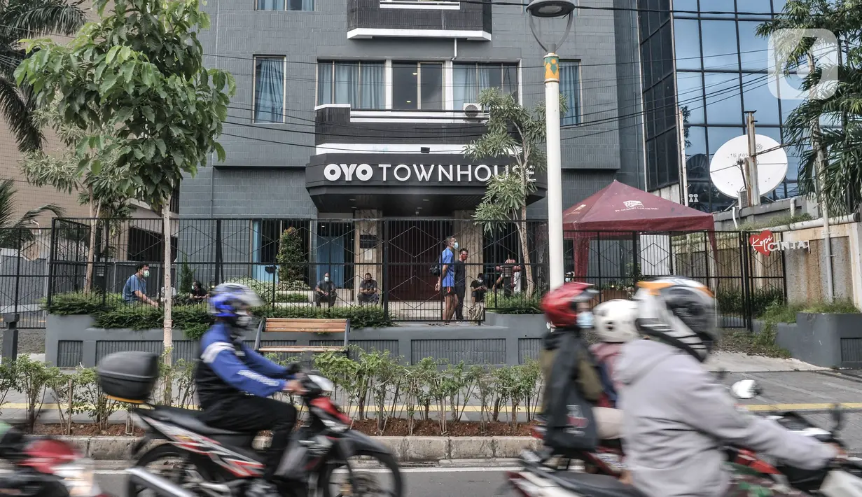 Pengendara motor melintas di depan pasien Covid-19 yang sedang berjemur di sebuah hotel kawasan Salemba, Jakarta, Senin (22/2/2021). Para pasien Covid-19 memilih hotel dengan alasan lebih nyaman dan privasi dibandingkan rumah sakit meskipun mengeluarkan biaya lebih.  (merdeka.com/Iqbal S. Nugroho)