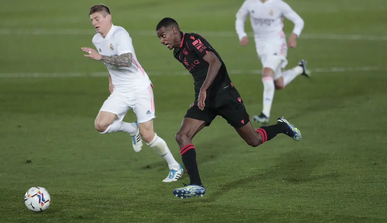 Penyerang Real Sociedad, Alexander Isak membawa bola dari kejaran gelandang Real Madrid, Toni Kroos pada pertandingan La Liga Spanyol di stadion Alfredo di Stefano, Spanyol, Selasa (2/3/2021). Jarak El Real dengan Atletico Madrid selaku pemuncak klasemen menjadi lima poin. (AP Photo/Bernat Armangue)
