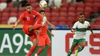 Bek Singapura, Irfan Fandi, tak memberikan ruang kepada Irfan Jaya untuk membangun serangan di semifinal Piala AFF 2020.(AFP/Roslan Rahman)