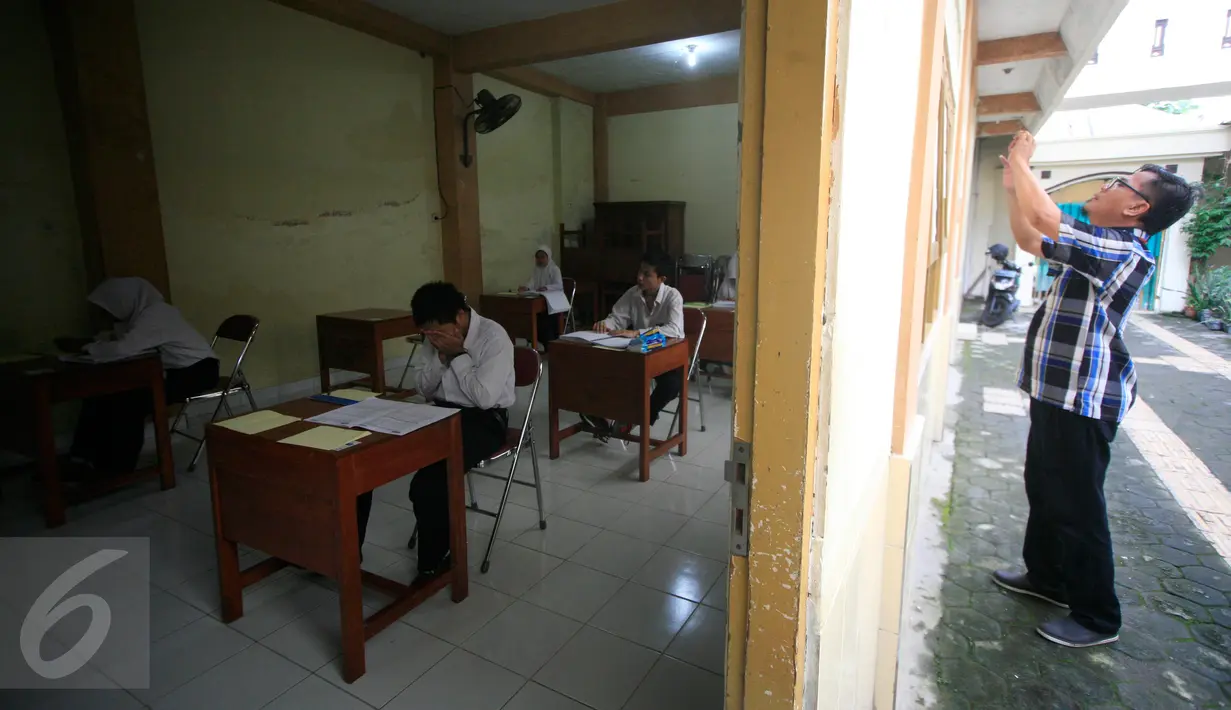 Seorang pria mengambil gambar ruang ujian tempat penyandang tunanetra mengikuti UN di MTs Yaketunis, Yogyakarta, Senin (9/5). Meski mengalami kekurangan fisik, tapi tidak menjadi penghalang bagi para siswa mengikuti UN. (Foto: Boy Harjanto)