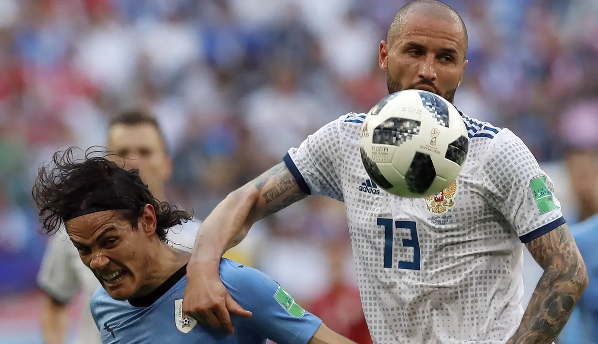 Duel pemain Uruguay, Edinson Cavani (kiri) dan pemain Rusia, Fyodor Kudryashov pada laga grup A Piala Dunia 2018 di Samara Arena, Samara, Rusia, (25/6/2018). Uruguay menang 3-0. (AP/Hassan Ammar)