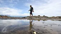 Seorang warga bermain air di sekitar Pantai Karang Hawu, Sukabumi, Jawa Barat, (8/2). ). Mengisi libur Imlek, Sejumlah wisatawan mengunjungi Pantai Karang Hawu. (Liputan6.com/Immanuel Antonius)