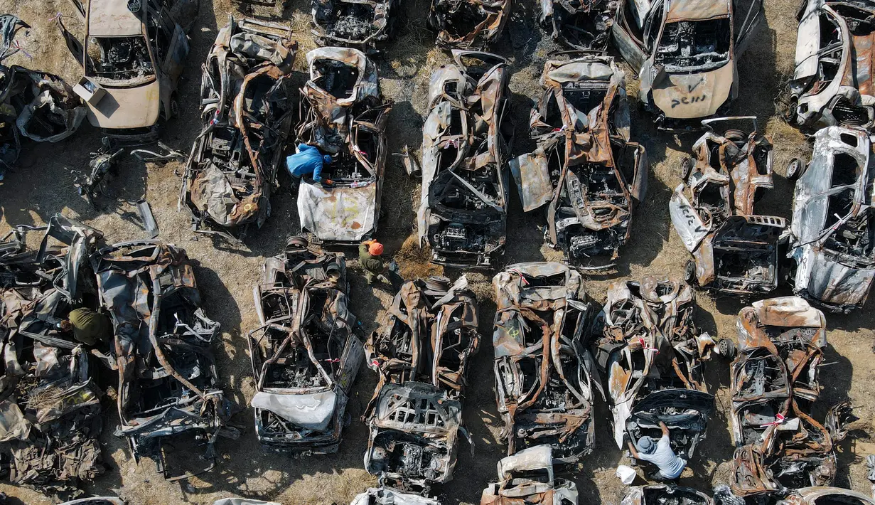 Pasukan keamanan Israel memeriksa kendaraan yang hangus terbakar dalam serangan 7 Oktober oleh militan Hamas di luar kota Netivot, Israel selatan, Rabu, 1 November 2023. (AP Photo/Ariel Schalit)