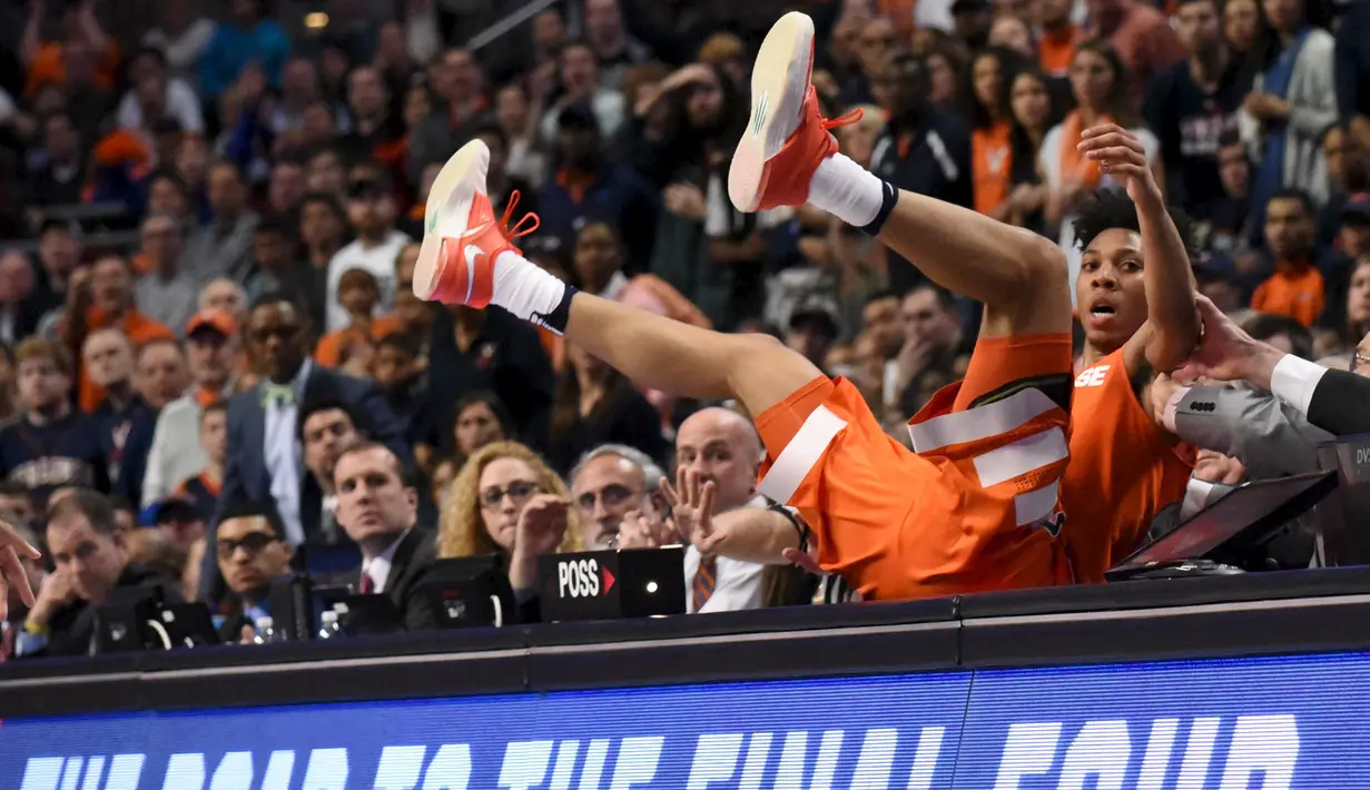 Guard Syracuse Orange, Malachi Richardson (23), terjatuh ke arah meja skor saat melawan Virginia Cavaliers dalam laga basket NCAA di United Center, Chicago, AS, (27/3/2016). (Reuters/David Banks-USA Today Sports)