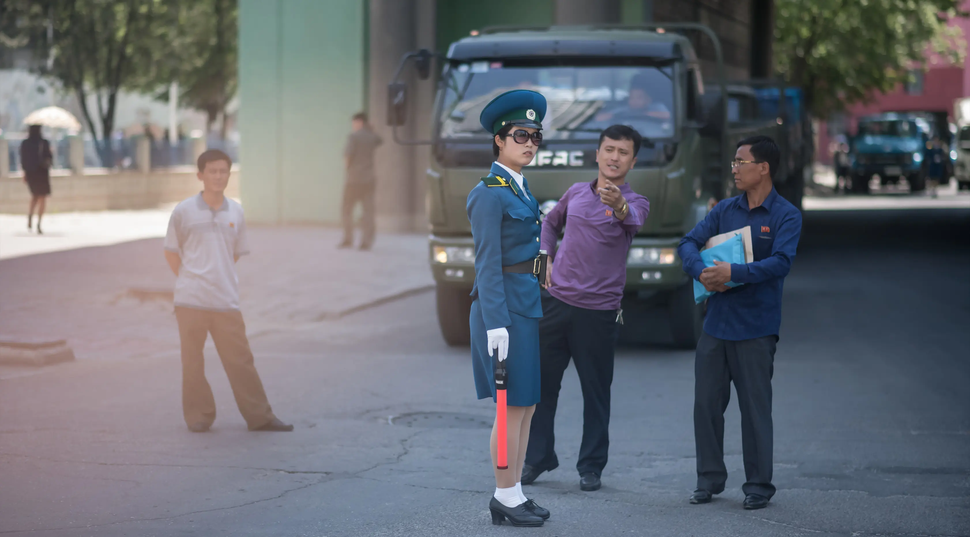 Seorang pejalan kaki berbicara dengan polisi wanita yang sedang mengatur lalu lintas di Pyongyang, Korea Utara (5/6). Polisi wanita pengatur lalu lintas ini juga menjadi daya tarik di kota Pyongyang. (AFP Photo/Ed Jones)