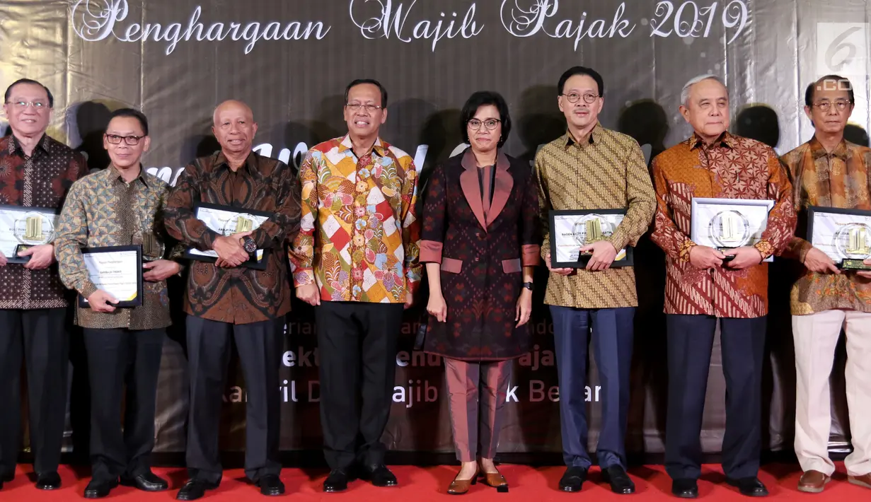 Menteri Keuangan Sri Mulyani (empat kanan) foto bersama dengan President Commissioner EMTEK Eddy Kusnadi Sariaatmadja (tiga kanan) usai memberikan apresiasi dan penghargaan di Kantor Pajak Kanwil DJP Jakarta, Rabu (13/3). (Liputan6.com/JohanTallo)
