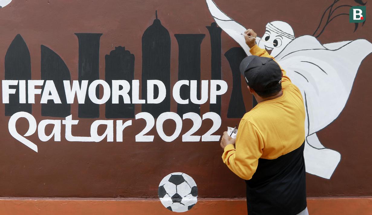 Warga menyelesaikan pembuatan mural bertema Piala Dunia 2022 di Perum Depok Maharaja Blok M1 Cluster Cemara, Rangkapan Jaya, Depok, Jawa Barat, Minggu (30/10/2022). (Bola.com/M Iqbal Ichsan)