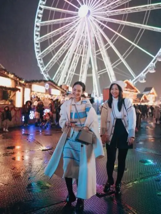 Enzy tampil modis dengan padu padan setelan knit top dan long coat warna putih. Makin kece, ia melengkapi penampilannya dengan sepatu boots. @enzystoria/@hestipurwadinata.