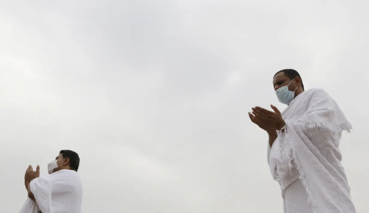 Sejumlah jemaah berdoa di depan bukit batu saat akan menunaikan puncak ibadah haji, wukuf di Arafah selama ibadah haji di luar kota suci Mekah, Arab Saudi (19/7/2021). Sebelum menjalani ibadah puncak, para jemaah haji menghabiskan waktu dengan berdoa hingga matahari terbit. (AP Photo/Amr Nabil)