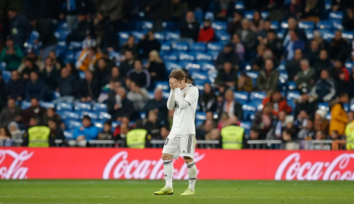 Pemain Real Madrid Luka Modric menutupi wajahnya usai bertanding melawan Real Sociedad pada laga pekan ke-18 La Liga Spanyol di Santiago Bernabeu, Minggu (6/1). Real Sociedad meraih kemenangan 2-0 atas Real Madrid. (AP Photo/Paul White)
