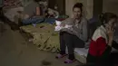 Seorang perempuan menggendong bayinya yang baru lahir di dalam ruang bawah tanah yang digunakan sebagai tempat perlindungan bom di rumah sakit anak Okhmadet di Kiev tengah, Ukraina, Senin (28/2/2022). Hingga kini invasi militer Rusia ke Ukraina terus berlanjut. (AP Photo/Emilio Morenatti)