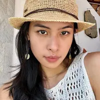 Maudy Ayunda diketahui menghabiskan liburan setelah Lebaran di Bali bersama keluarganya. Di foto ini, ia memperlihatkan potret dirinya bare face, tanpa riasan sama sekali. Ia hanya menambahkan aksesori berupa anting dan topi. Foto: Instagram.