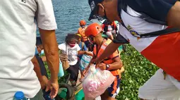 Keluarga dievakuasi ke tempat yang lebih aman di provinsi Camarines Sur, Filipina (31/10/2020). Otoritas Filipina memerintahkan satu juta orang di negara itu agar mengungsi dari rumah mereka. (Philippine Coast Guard via AP)