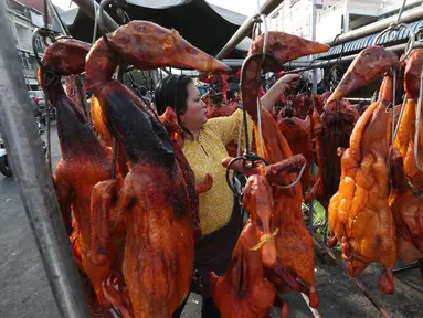 Pedagang menyiapkan babi panggang untuk perayaan Tahun Baru Imlek di Phnom Penh, Kamboja, Jumat (24/1/2020). Babi panggang menjadi menu santapan wajib bagi warga Tionghoa yang merayakan Imlek. (AP photo/Heng Sinith)