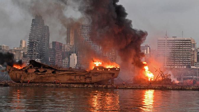 Sebuah kapal besar yang terbakar setelah ledakan besar di pelabuhan Kota Beirut, Lebanon (5/8/2020). Kuatnya ledakan di Beirut sampai kapal tersebut terangkat ke Daratan dan hancur. (AFP Photo)