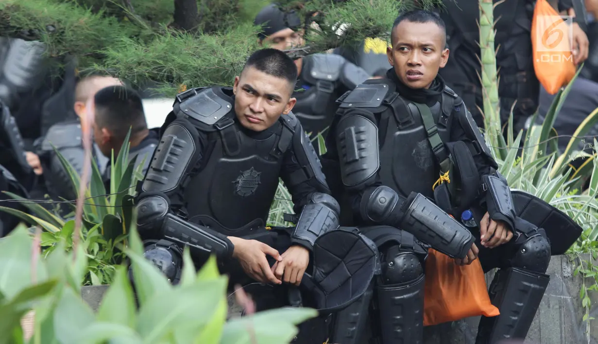 Personil kepolisian dari satuan Brimob beristirahat saat menjaga aksi unjuk rasa yang dilakukan Gerakan Nasional Kedaulatan Rakyat di depan Gedung Bawaslu, Jakarta, Selasa (21/5/2019). Ribuan aparat keamanan gabungan diterjunkan untuk mengamankan jalannya aksi. (Liputan6.com/Helmi Fithriansyah)