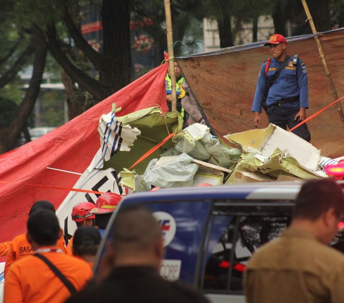 Proses evakuasi badan pesawat tersebut juga ditutup dengan terpal. Foto: merdeka.com / Arie Basuki
