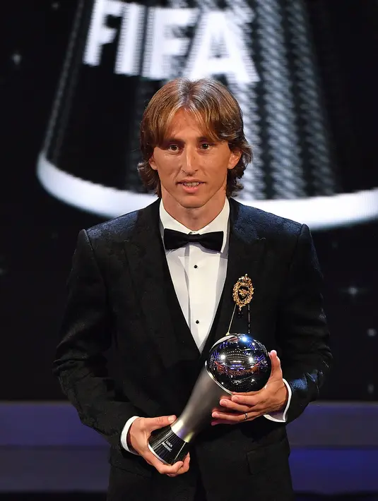 Bintang sepak bola Kroasia, Luka Modric berpose dengan trofi Pemain Terbaik Pria FIFA 2018 dalam The Best FIFA Football Awards di London, Senin (24/9). Torehan itu pun menghentikan dominasi Ronaldo dan Messi selama satu dekade terakhir. (Ben STANSALL/AFP)