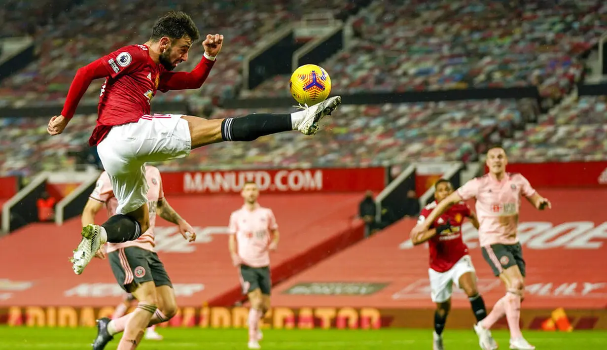 Gelandang Manchester United, Bruno Fernandes, menendang bola saat melawan Sheffield United pada laga Liga Inggris di Stadion Old Trafford,  Kamis (28/1/2021). MU takluk dengan  skor 1-2. (AP/Tim Keeton,Pool)