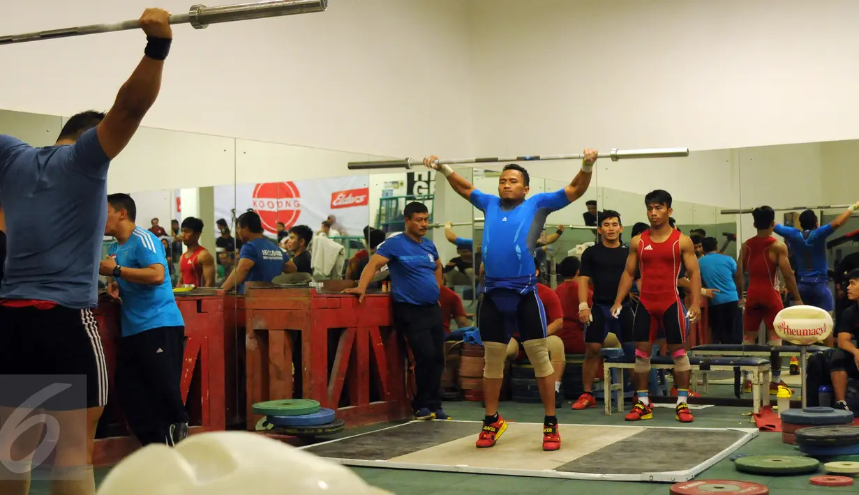 Atlet angkat besi, Triyatno (tengah) saat melakukan pemanasan jelang seleksi nasional untuk olimpiade Rio de Janeiro 2016 di PB PABBSI, Jakarta, Sabtu (4/6/2016). (Liputan6.com/Helmi Fithriansyah)